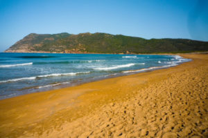 bellissima spiaggia in sardegna dal colore rosso e giallo di giorno