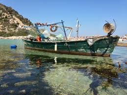 barca attraccata ad un tipico molo sardo, in una spiaggia in sardegna