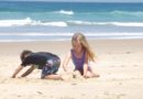 Bambini che giocano sulla spiaggia con la sabbia