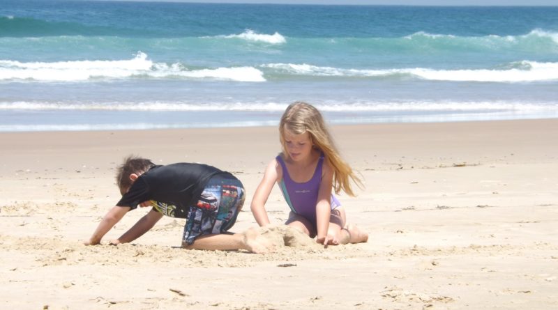 Bambini che giocano sulla spiaggia con la sabbia